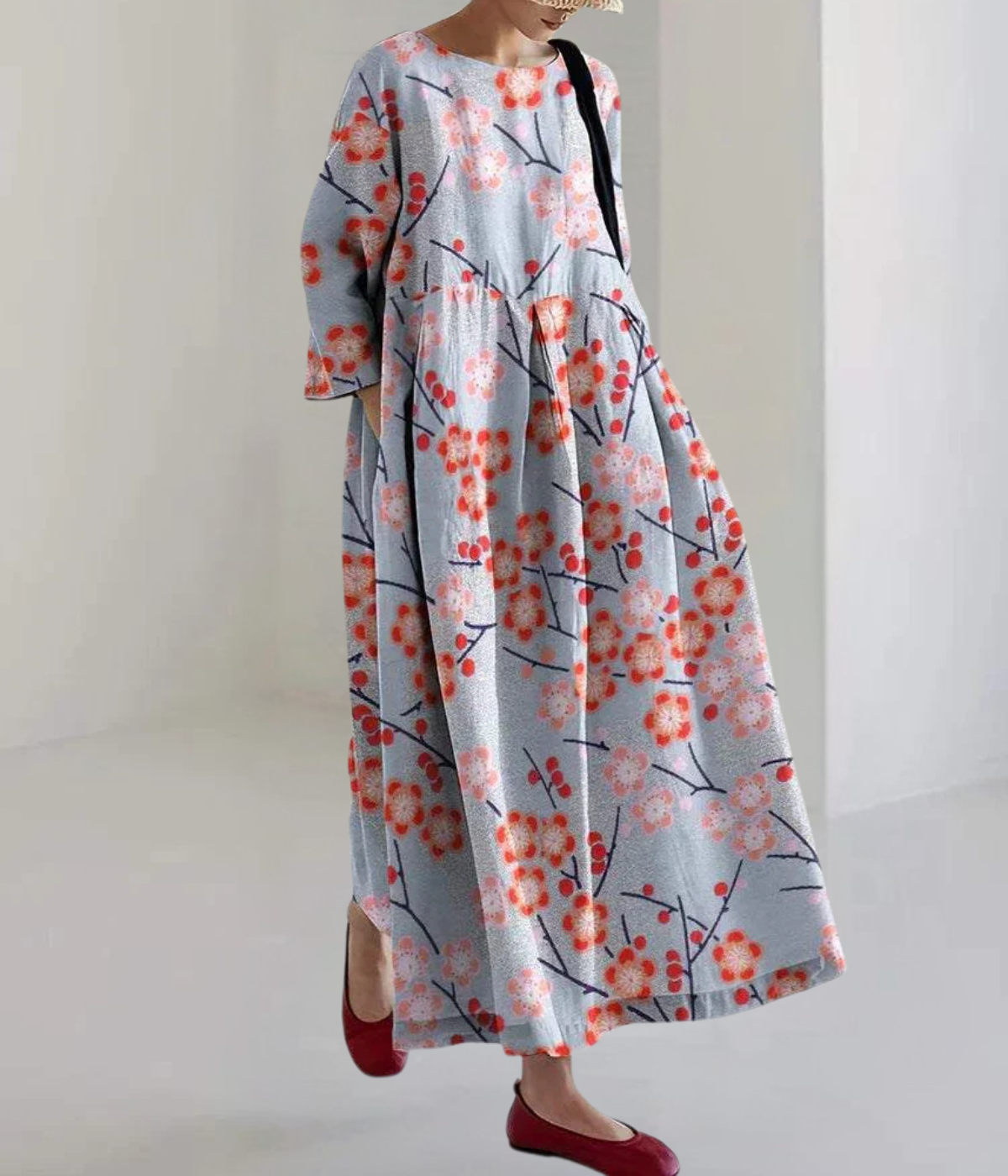 赤い花がついた青い丸首のドレス